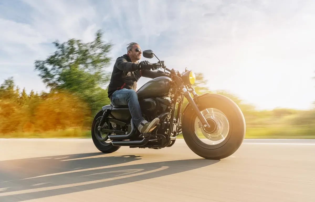 A man on a motorcycle speeding down the road.