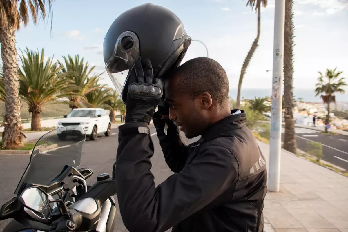 A rider slipping on his helmet going for his first ride on his Harley-Davidson beginner bike.