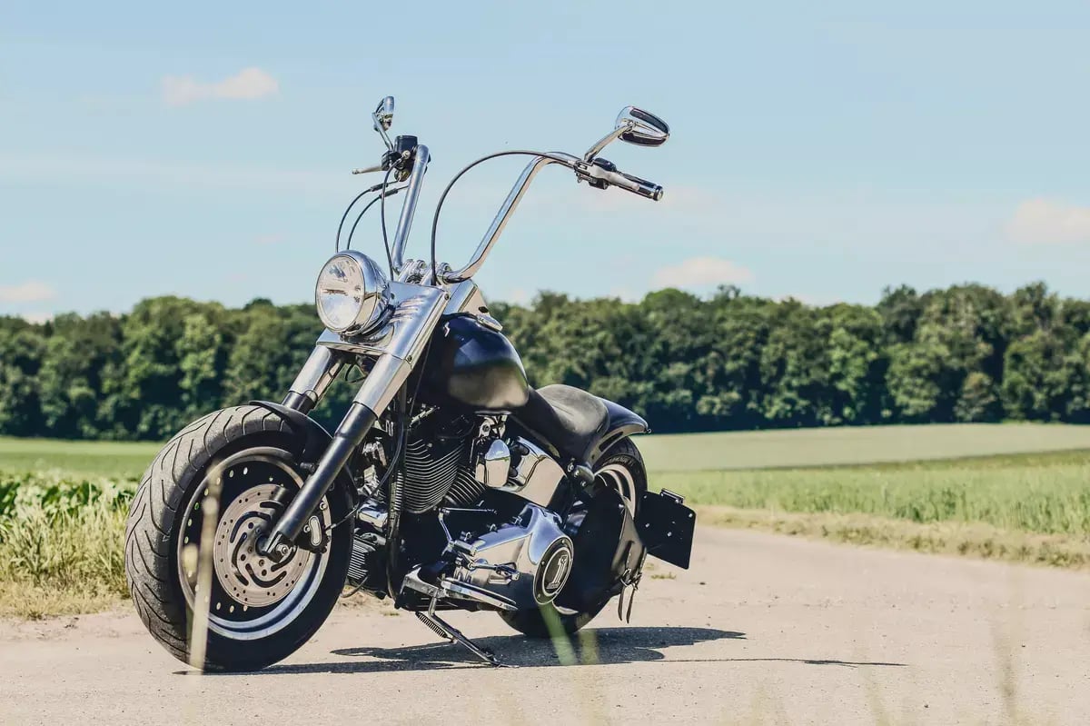 black motorcycle without a driver stands on a dirt road, sideview