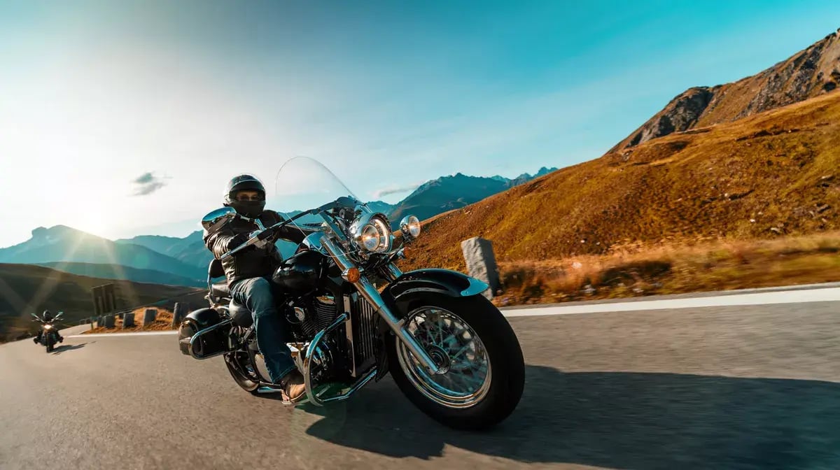 Motorcyclists riding on highway at dawn.