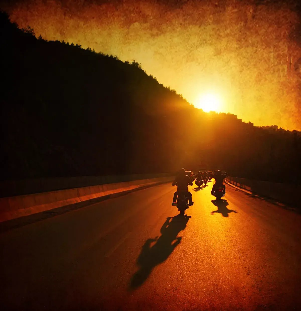 People riding their motorcycles into the sunset.