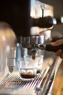 Waitress making cup of coffee in cafx92xA9