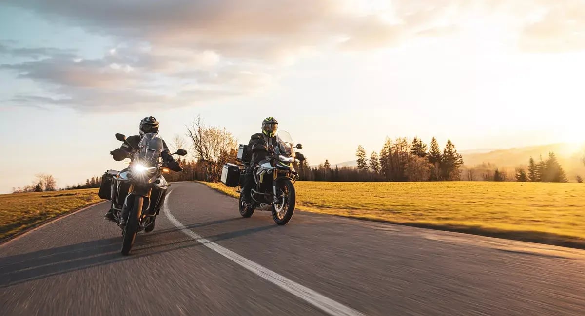 Two Drivers Riding Motorcycle on Empty Road During Sunset.