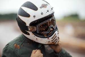 man wearing a dirty harley davidson motorcycle helmet